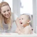 Une mère faisant la toilette à son bébé