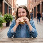 Jeune femme dégustant un sandwich en extérieur à SaintLouis