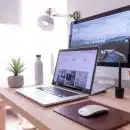 MacBook Pro on table beside white iMac and Magic Mouse