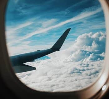 person taking picture of plane wings while flying during daytime