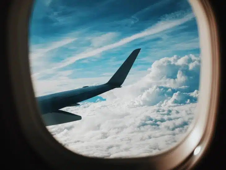 person taking picture of plane wings while flying during daytime