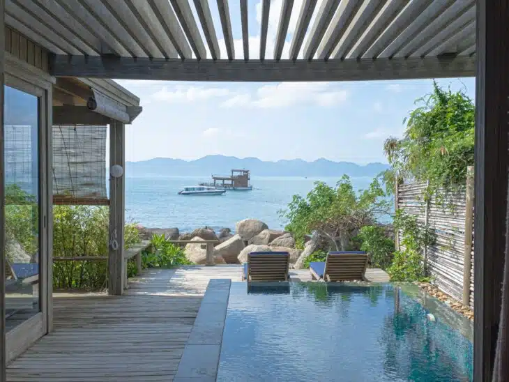 brown wooden chairs near swimming pool during daytime