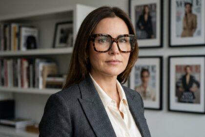 Femme élégante portant des lunettes oversize en écaille de tortue dans un bureau éditorial moderne, style personnalité médiatique